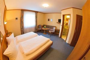 霍夫格鲁纳灵德兰德酒店的酒店客房配有一张床铺和一张桌子。