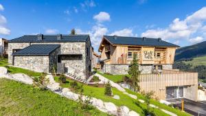 克里姆尔Stadl Lofts Plattenalm - Premiumchalets - Zillertal - Tirol - Salzburg的山丘上一座石头房子,屋顶黑色