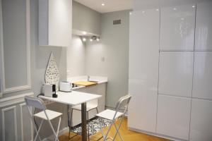 巴黎Residence sur Cour的厨房配有桌椅和冰箱。