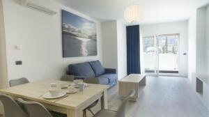 托斯科拉诺-马德尔诺Piamarta Apartments的客厅配有桌子和蓝色沙发