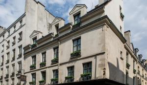 巴黎查理五号公寓的一座白色的大建筑,上面有盆栽植物
