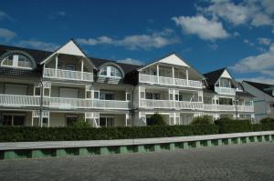 卡尔斯哈根Hafenidyll mit Wasserblick的白色的大公寓大楼设有白色阳台