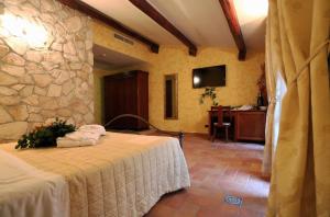 拉奎拉Hotel L'Aquila的一间卧室设有一张床和石墙