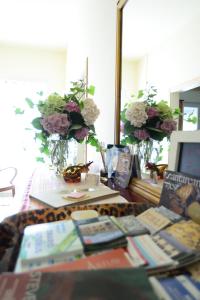 切塞纳Bed and Breakfast Lucia的一张桌子,里面放着书籍和鲜花