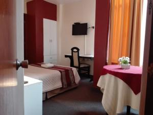 利马Los Q'eros的酒店客房配有一张床和一张桌子及椅子