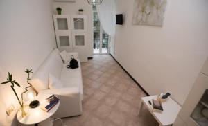 罗马多莫斯阿梅卡旅馆的客厅配有白色的沙发和桌子