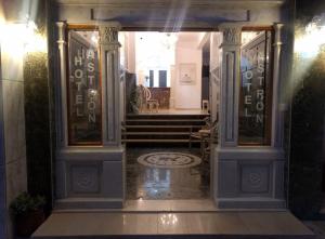 米里纳Hotel Astron的进入有柱子和楼梯的建筑的入口