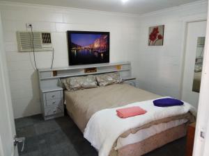 BoulderBurt St gardens的卧室配有一张床铺,墙上配有电视