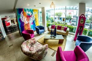 基多基多安贝斯酒店的客厅配有粉色和蓝色的椅子和时钟