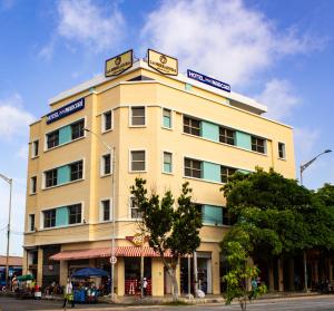 巴兰基亚Hotel Med Centro - Marcari的上面有标志的黄色建筑