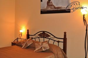 别尔哥罗德萨鲁酒店的一间卧室配有一张带两盏灯和一张照片的床。
