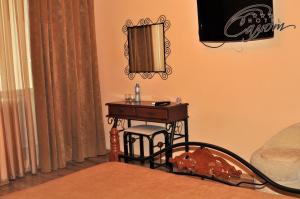 别尔哥罗德萨鲁酒店的一间卧室配有一张小桌子和镜子