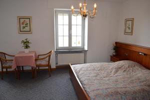 贝尔多夫肯尼酒店的一间卧室配有一张床、一张桌子和一个窗户。