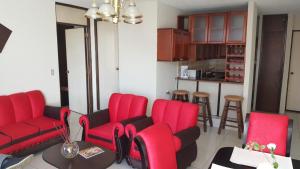 危地马拉Apartment business/airport area Guatemala City的一间带红色椅子的客厅和一间厨房