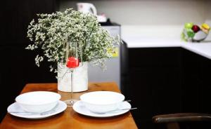 罗勇三颗星公寓式酒店的一张桌子,上面放着两个碗和花瓶