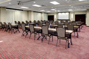 里士满里士满机场凯悦酒店的一间会议室,配有桌椅和屏幕
