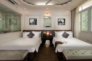 河内金鸡酒店的一间客房配有两张床、一张桌子和两把椅子