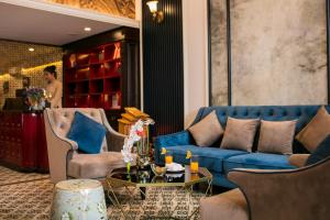 河内金鸡酒店的客厅配有蓝色的沙发和椅子