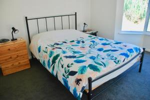 维克多港Back Valley Farmstay Bed and Breakfast的一间卧室配有一张带蓝白色毯子的床