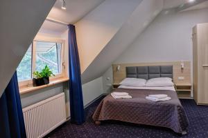 Górzno博雅德克酒店的一间卧室配有一张床,上面有两条毛巾