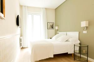 萨拉戈萨索斯酒店的卧室配有白色的床和窗户。
