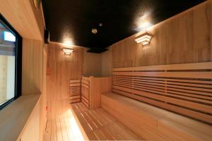 神户神户托尔路坎迪奥酒店的一间带木镶板和灯的桑拿浴室