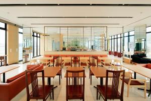 神户神户托尔路坎迪奥酒店的餐厅设有木桌、椅子和窗户。