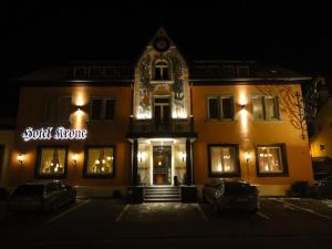 里拉辛根-沃布林根克朗酒店的一座建筑,在晚上前有标志