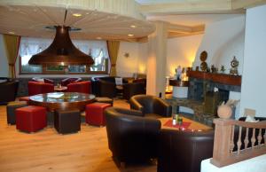 蒂罗尔-基希贝格基希贝格公园酒店的一间带桌椅和大钟的餐厅