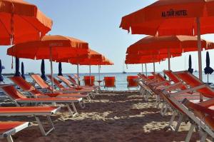 圣维托罗卡波安泰尔酒店的海滩上的一组椅子和遮阳伞