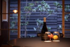 大津Hotel Koo Otsuhyakucho的桌子上放有一瓶葡萄酒和两杯酒
