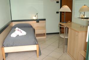 罗索利纳格兰三角洲酒店的客房设有一张床、一张桌子和一张桌子。
