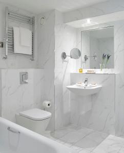 基尔肯尼新公园酒店的白色的浴室设有卫生间和水槽。