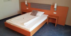 古森多夫福鲁克斯佩威特酒店的一间卧室配有一张带橙色床头板的大床