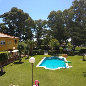 马拉加La Baraka de Guadalmar B&B Aeropuerto , Free breakfast的后院,草地上设有游泳池