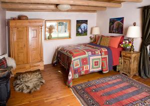 陶斯Casa Gallina - An Artisan Inn的一间卧室配有床、橱柜和地毯