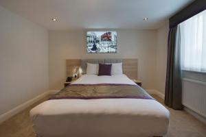 伦敦OYO Townhouse 30 Sussex Hotel, London Paddington的一间卧室设有一张大床和一个窗户。