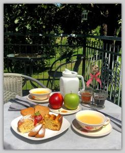 MelazzoCascina Luvot的餐桌,盘子上放有面包和水果,茶壶