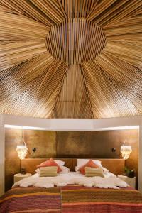 圣佩德罗·德·阿塔卡马Hotel Desertica的一间卧室设有一张带木制天花板的大床