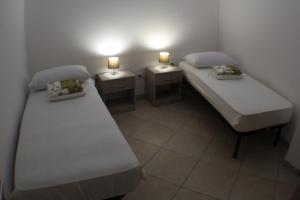 穆罗莱切塞Locazioni turistiche POZZODONTE e MESSAPIA的两张床铺,房间有两个灯