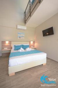 斯卡拉索提罗斯Yalos Beach Maisonettes的一间卧室配有一张带蓝色枕头的大床