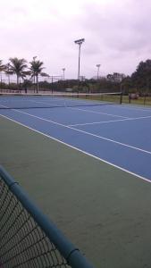 曼加拉蒂巴Loft com Praia的一座带网和棕榈树的网球场