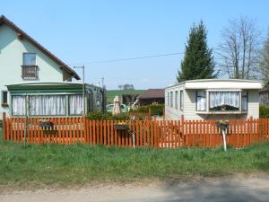 索博特卡Ubytovani v mobilnim domku的一座房子旁边设有橙色围栏的房子