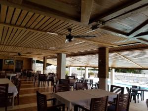 巴拉奥纳省圣克鲁斯Hotel El Quemaito - Luxury Oceanfront Retreat的一间带桌椅和天花板的用餐室