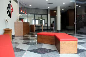 阿尔苏阿HOTEL ARZÚA的大楼里设有红色长凳的大堂