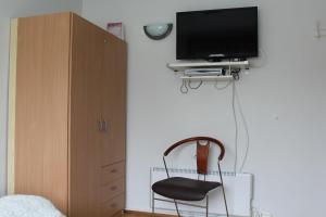 斯科加尔弗斯Fosstún Guesthouse的一间卧室配有椅子和墙上的电视