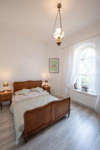 隆代克-兹德鲁伊Apartament Zamkowy的一间卧室设有一张大床和一个窗户。