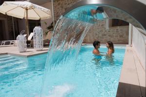 阿尔库迪亚Forum Boutique Hotel & Spa - Adults Only的瀑布游泳池中的男女