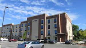 博伊西Comfort Inn & Suites Boise Airport的停车场内停放汽车的大型建筑