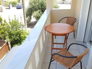 海若克利欧Minimalistic Studio Apartments的阳台配有一张小桌子和两把椅子